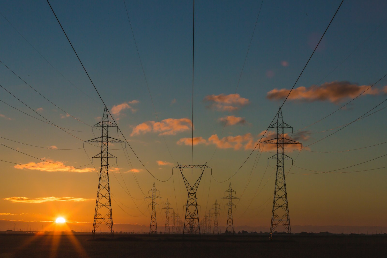 Hoogspanningsmasten tegen een avondlucht, met de opgewekte stroom op weg naar het net.